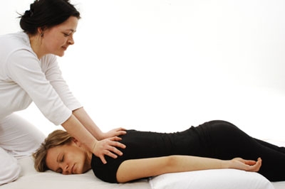 A woman receiving a back massage from another woman.
